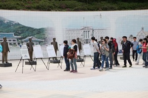 역대 대통령선거 정보 안내판을 구경중인 관람객