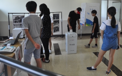 주권함양 캠페인에 앞서 본인확인기 및 투표용지발급기 등을 통해 공직선거를 체험해보는 청소년들의 모습을 촬영한 사진입니다.