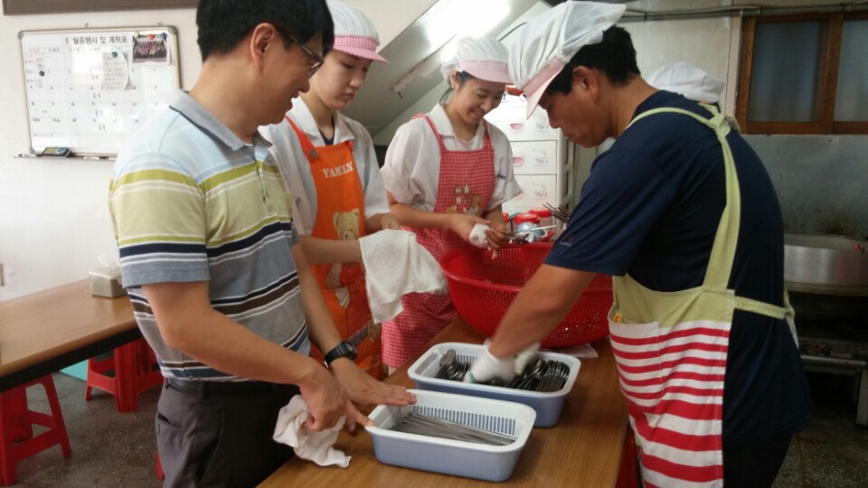 배식 종료 후 세척된 식기의 물기를 닦고 있는 모습