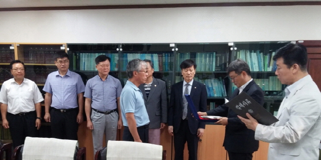 2015. 8. 31.자 명예퇴직 직원에게 화성시선관위위원장이 재직기념패를 수여하고 있는 사진