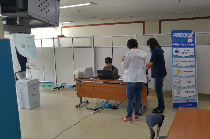 모의신분증을 이용하여 본인확인 후 투표용지발급기로 투표용지를 발급받는 모습
