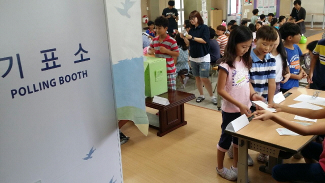 투표용지를 교부 받고 기표소 앞에서 투표하기 위하여 줄을 서고 있는 학생들의 모습