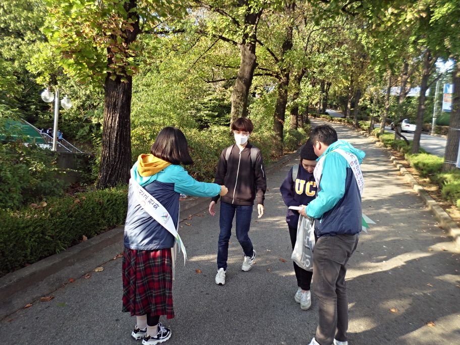 오산시선거관리위원회 직원들이 오산대학교 학생들에게 홍보용품을 나눠주며 제20대 국회의원선거에 대한 투표참여를 당부하고 있는 모습의 사진입니다