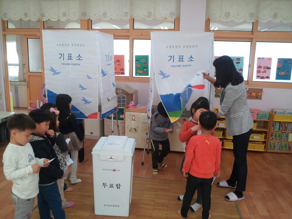 투표하기 위해 기표소 앞에 줄지어 서 있는 아이들의 모습