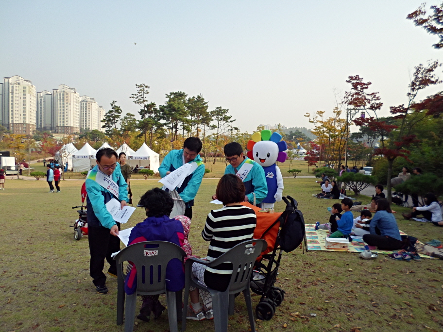 오산시선관위 직원들이 제6회 독산성문화제를 찾은 시민들에게 내년도 국회의원 선거일정에 대해 안내하며 홍보물품을 전달하고 있는 모습의 사진입니다