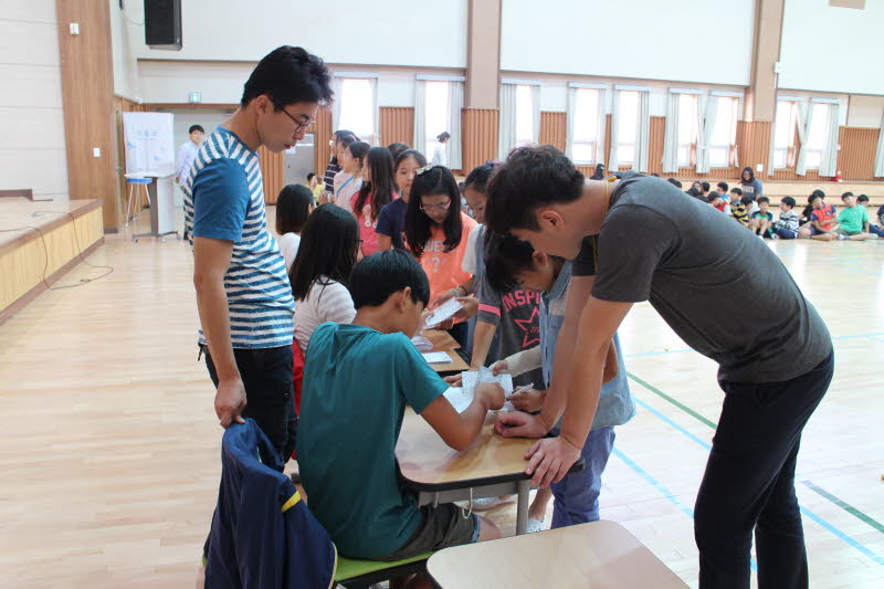 학생들이 투표하기 위해 명부를 확인하고 있습니다.