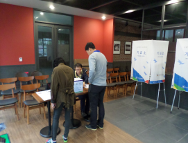 입주민들이 투표하기 위해 명부를 확인하고 있습니다.