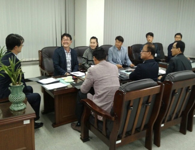 용인시수지구선거관리위원회 위원장, 위원 및 사무국장이 위원회의실에 둘러 앉아 위원회의를 하고 있는 모습의 사진