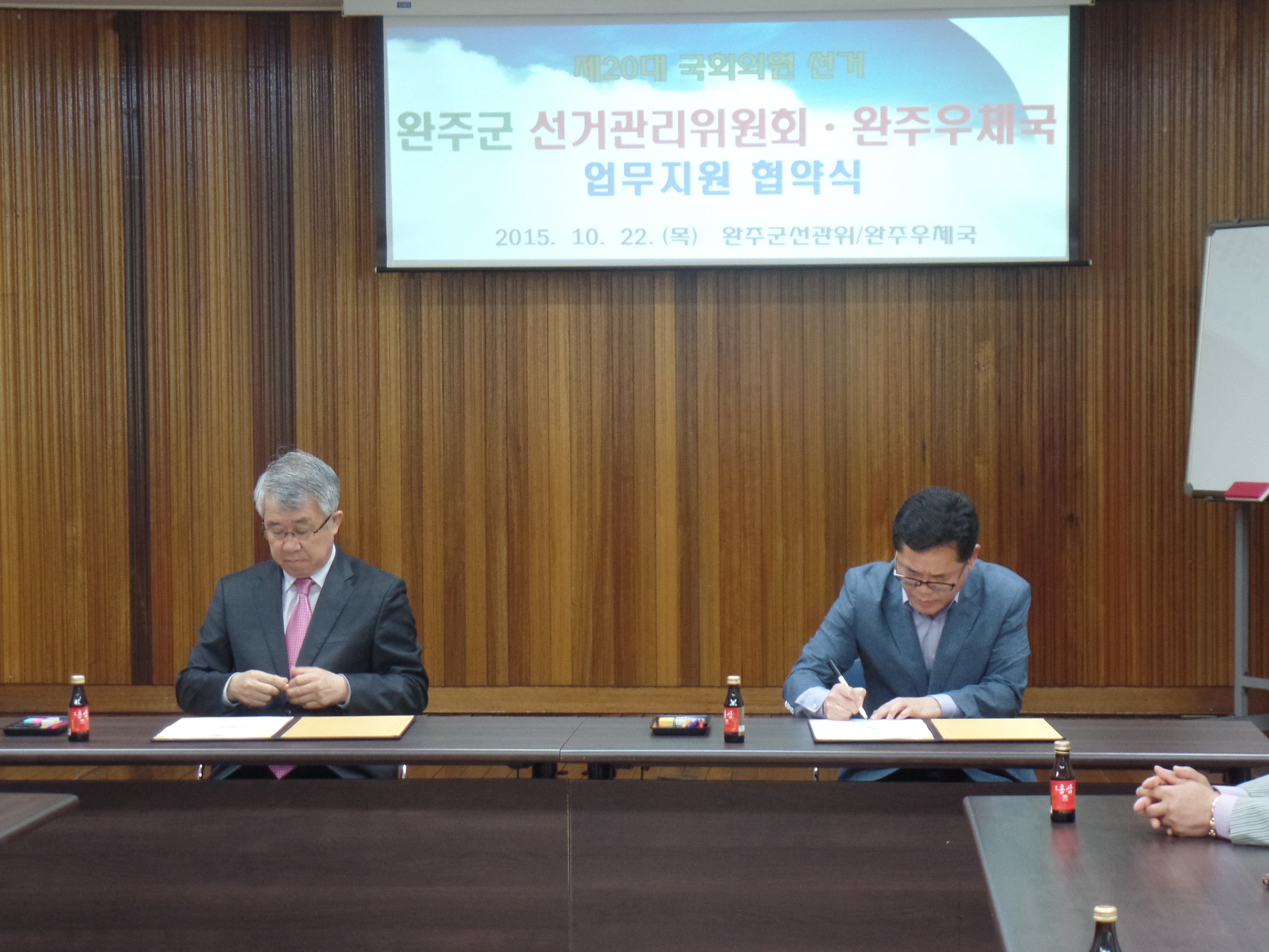 업무협약서에 서명을 하고 계십니다. 좌측이 완주우체국 이관수 우체국장님이시고, 우측은 따로 설명이 필요없으시겠죠?