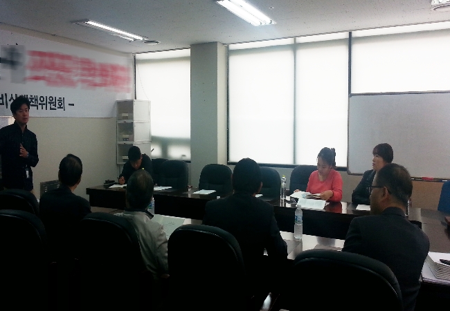 위원회 직원이 래미안이스트팰리스아파트3단지 입주자대표회의실에서 아파트선거관리위원 등에게 공동주택선거 교재를 살펴보며 아파트선거 관련 내용을 설명하고 있는 모습