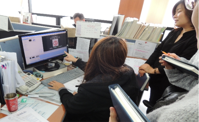 직원들과 함께 제작한 동영상을 컴퓨터로 시청하며 의견을 나누는 장면