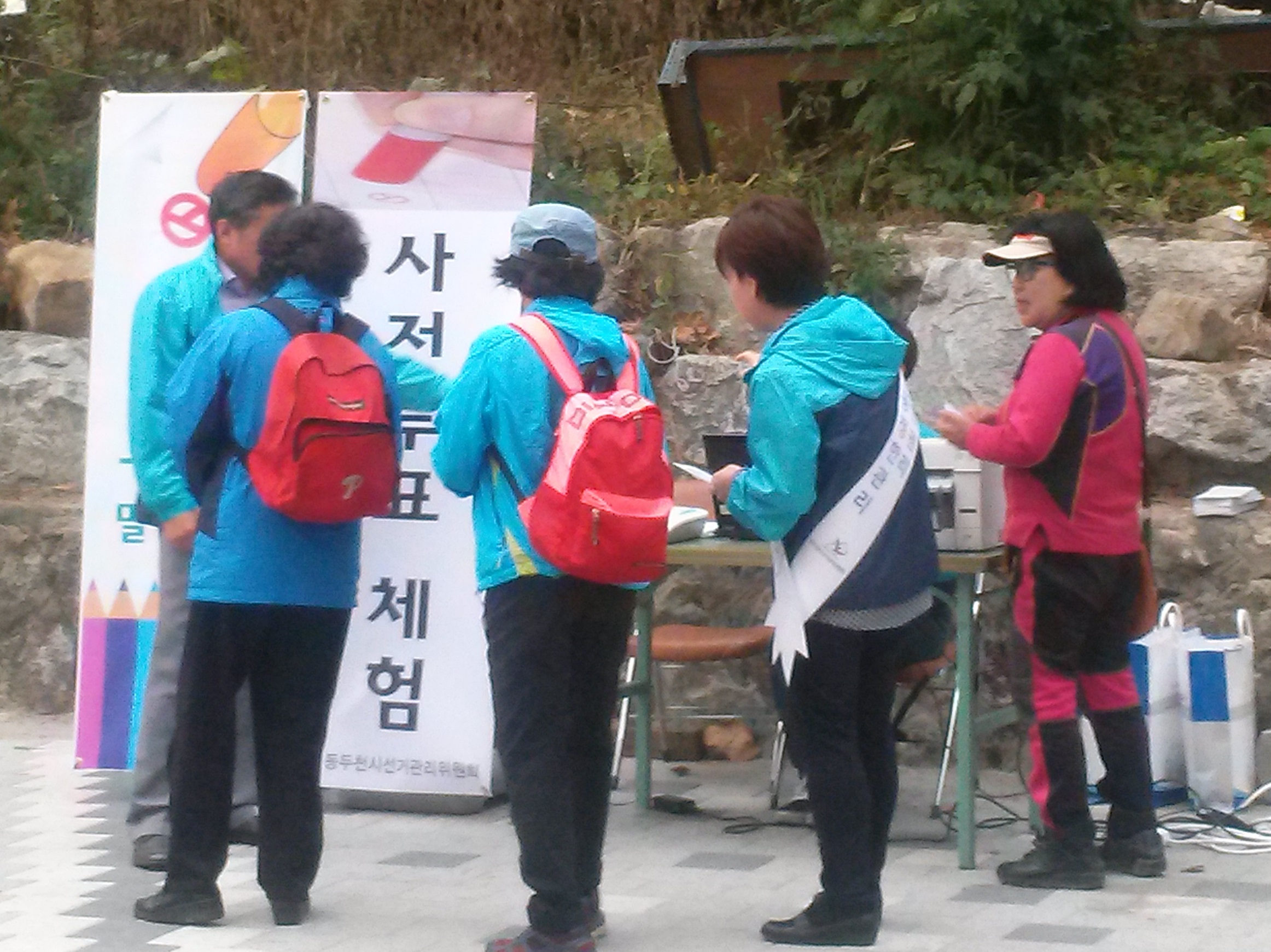 소요산입구에서 등산객들에게 사전투표 장비 및 절차를 설명하고 있는 위원회 직원