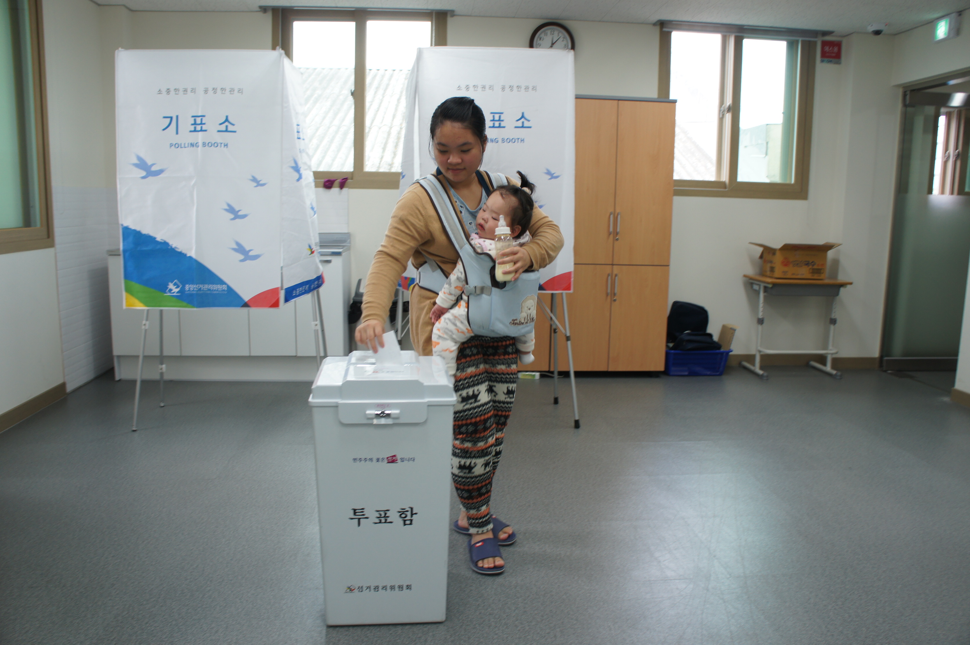 아이를 안고 투표하는 모습
