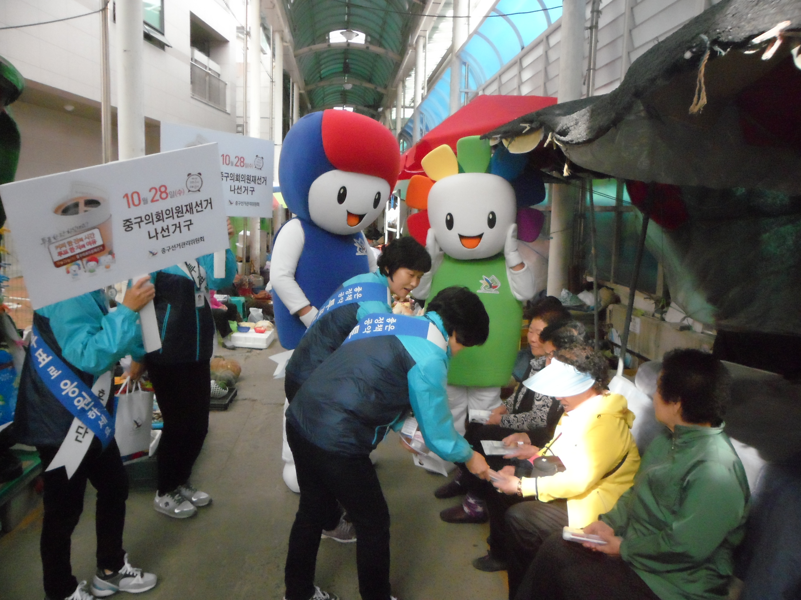 시장에 나오신 어른신들에게 리플릿 제공