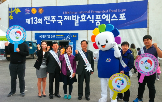 제13회 전주국제발효식품엑스포 라는 현수막이 크게 붙어 있고 그 앞에서 선거관리위원회 직원들이 어깨띠를 매고 피켓을 들고 화이팅을 외치고 있는 모습