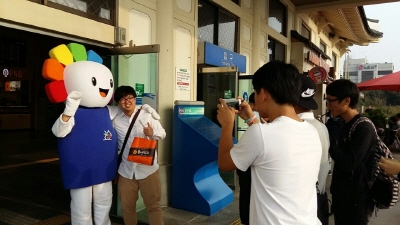 전주 방문객과 선관위 홍보 캐릭터 참참이가 함께 기념사진을 찍고 있는 모습