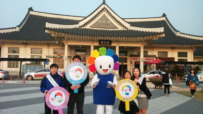 전주역 건물이 배경으로 보이고 선관위 홍보요원들이 어깨띠를 매고 피켓을 들고 단체로 서 있는 모습