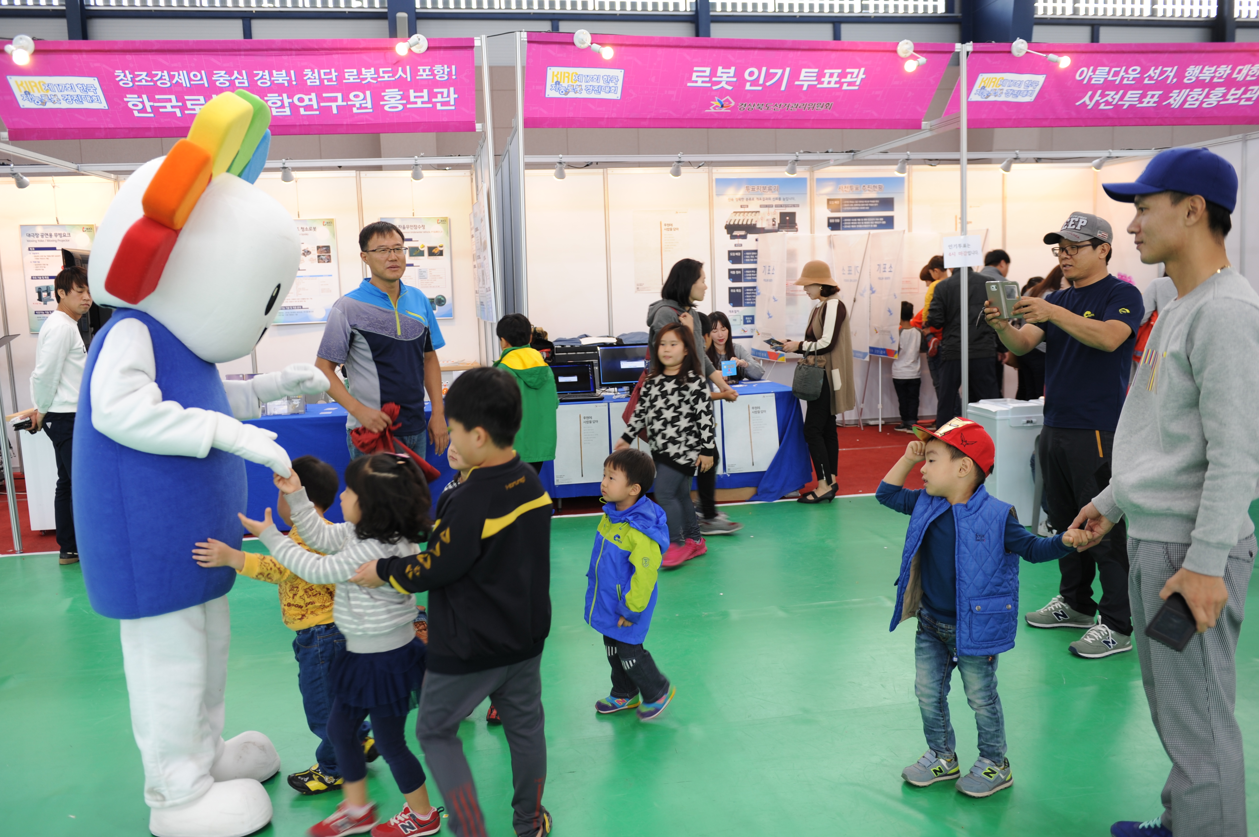 위원회 캐릭터인 참참이와 관람객 어린아이가 함께 즐거워하는 모습