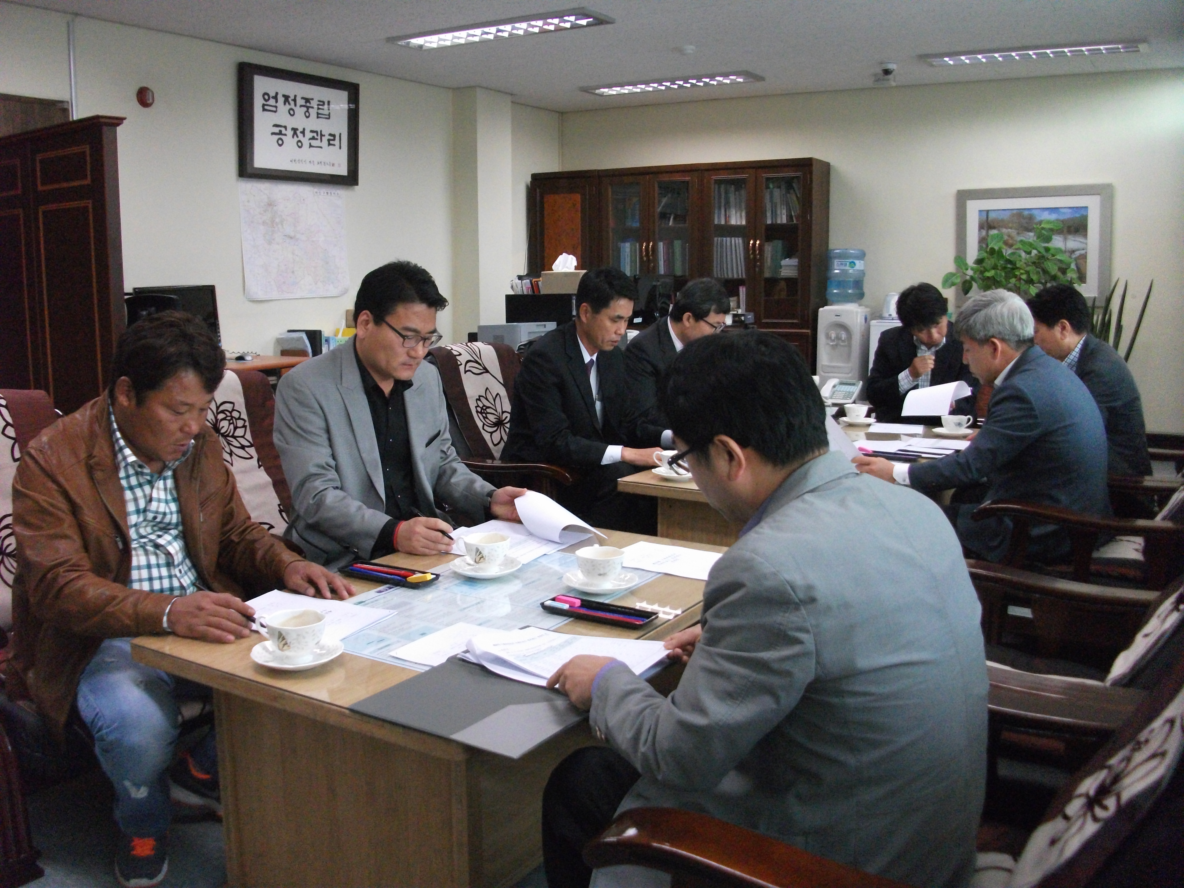 용인시처인구선거관리위원회 위원장, 위원 및 사무국장 등이 위원회의실에서 위원회의를 하고 있는 모습의 사진