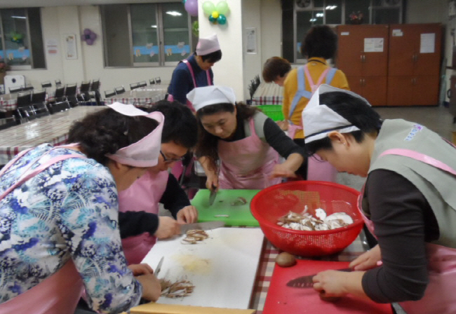 위원회 직원 등이 점심식사에 사용할 버섯을 칼로 채써는 모습