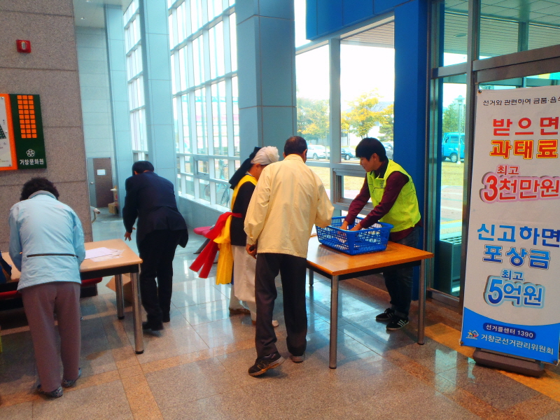 정치자금 홍보용 리플릿을 사람에게 배부하고 있는 장면입니다.
