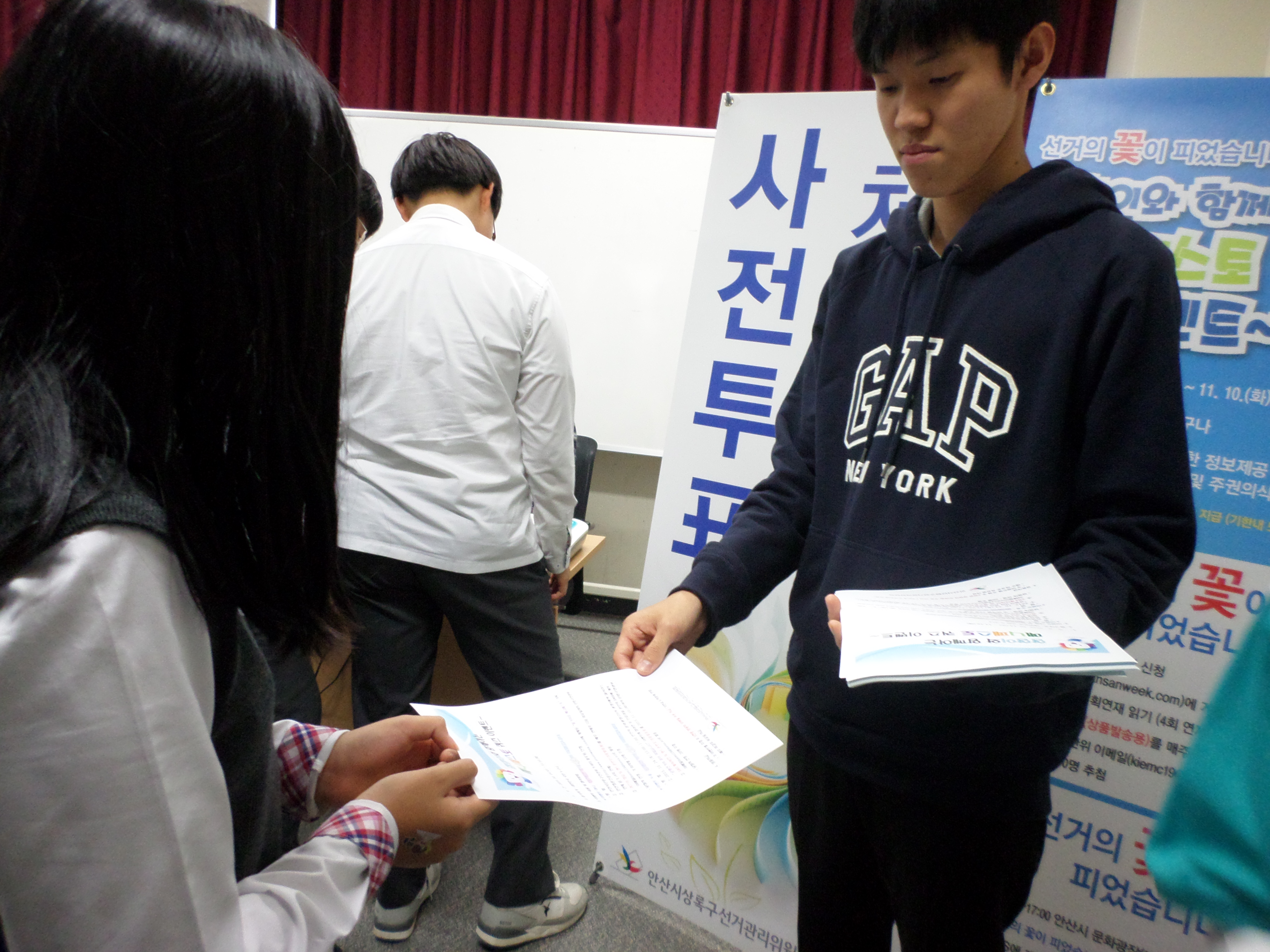 학생들에게 정책선거의 꽃이 피었습니다 홍보 인쇄물을 배부하는 모습