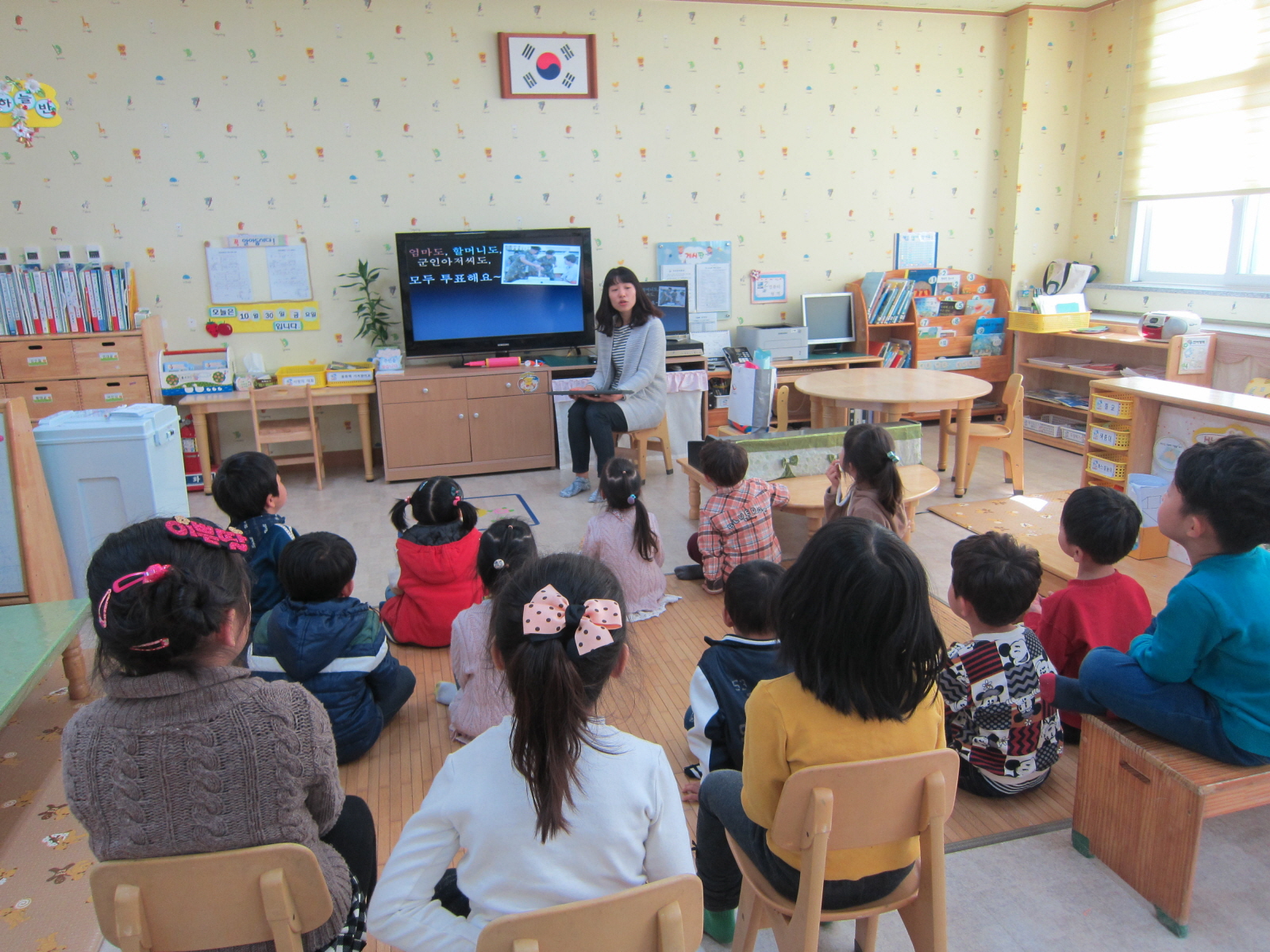 유치원 어린이들이 PPT를 통해 민주시민교육을 받고 있습니다.