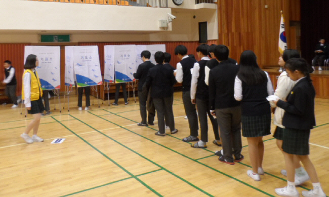 투표현장 사진 학생들이 투표를 하기 위해 기표소 밖에 일렬로 줄서서 기다리는 모습