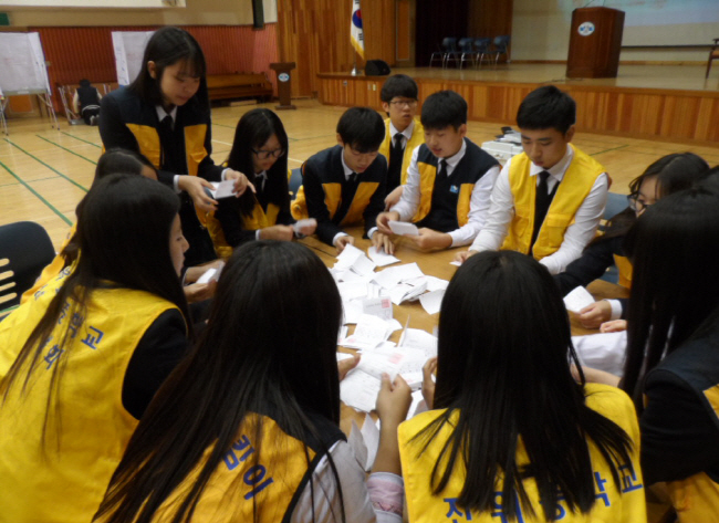 후보자별로 투표용지를 분류하는 개표하는 학생들의 모습