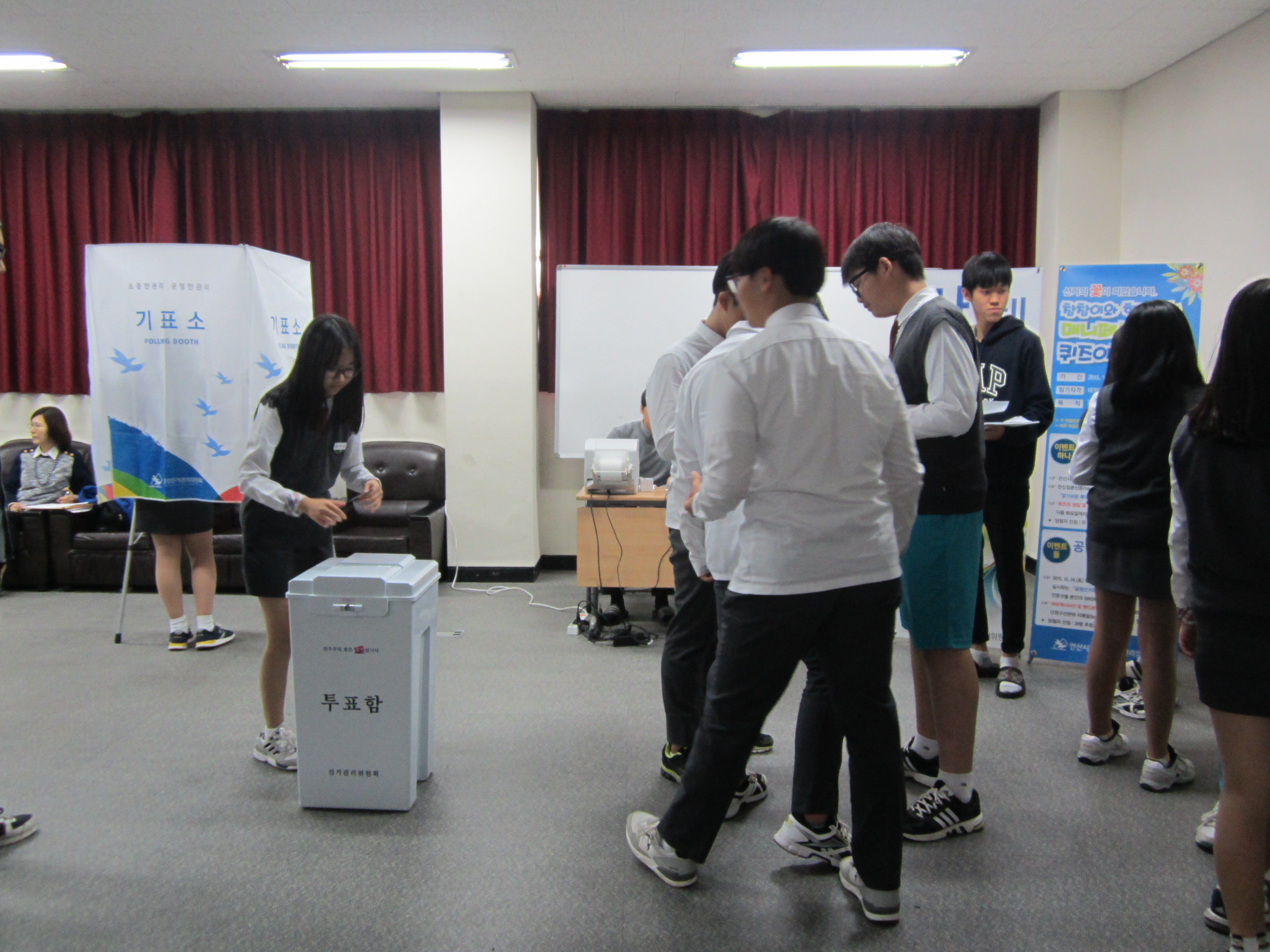 학생들이 사전투표운용장비 등을 이용하여 투·개표과정을 체험하고 있는 모습의 사진입니다.