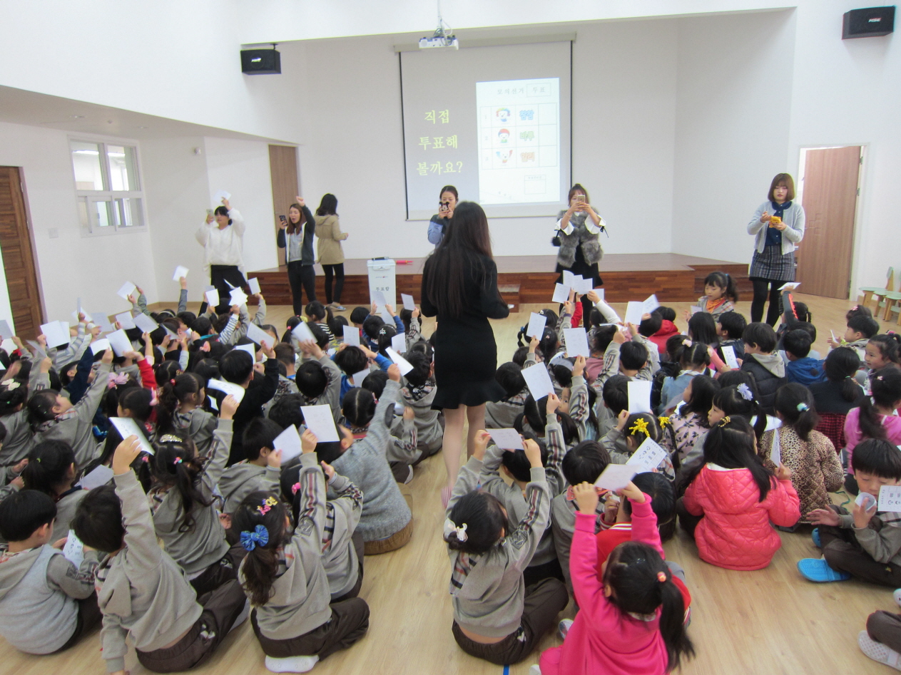 아이들이 배부받은 투표지를 흔들어 보이고 있습니다.