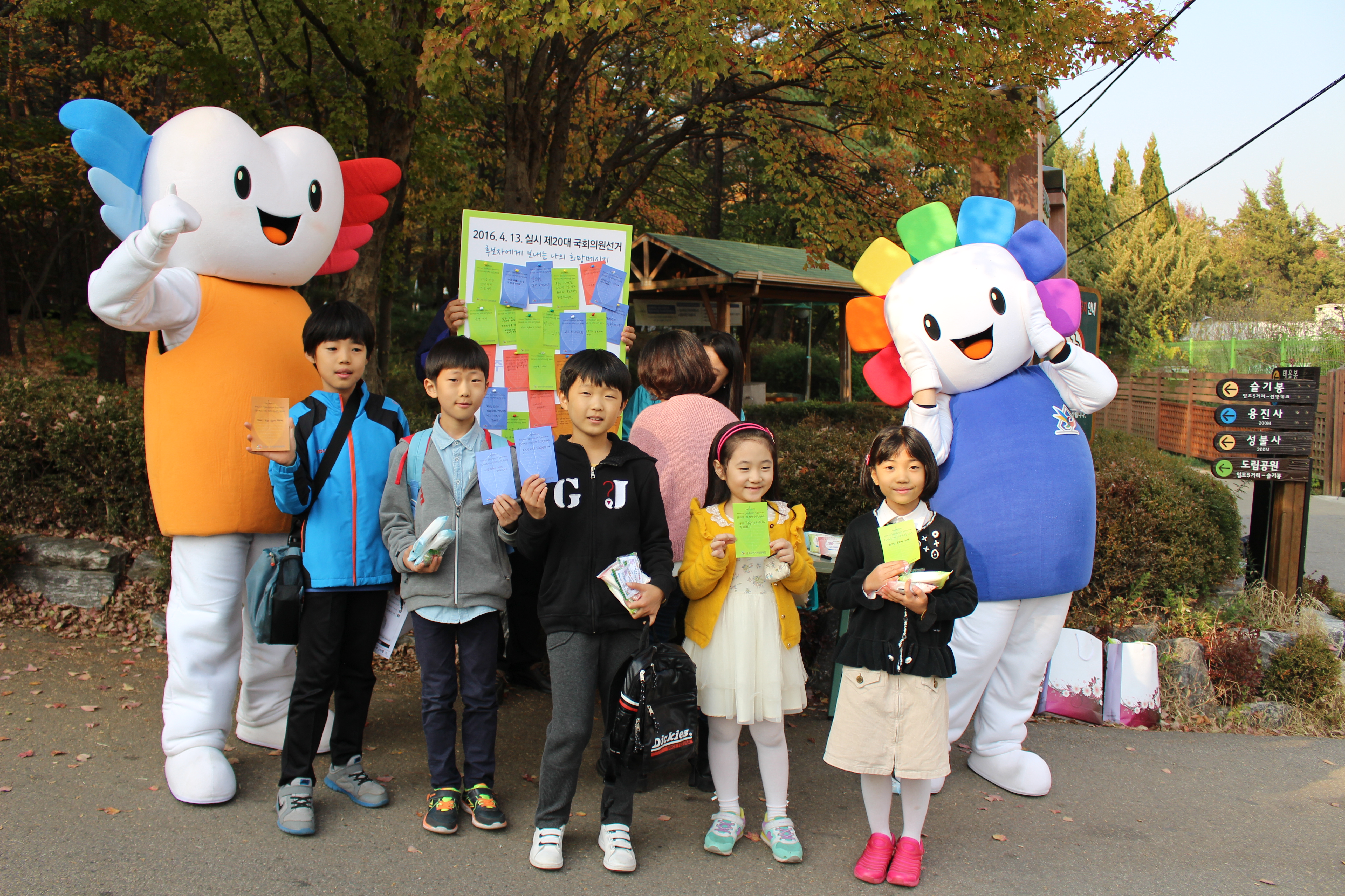 학생들이 국회의원선거 후보자에게 바라는 희망메시지 적기 캠페인에 참여한 후 메시지를 들고 사진을 찍기 위해 포즈를 취하고 있는 모습의 사진입니다.