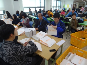 위원회 직원 등이 장애우와 함께 재활훈련 생산품을 제작하는 모습의 사진입니다.