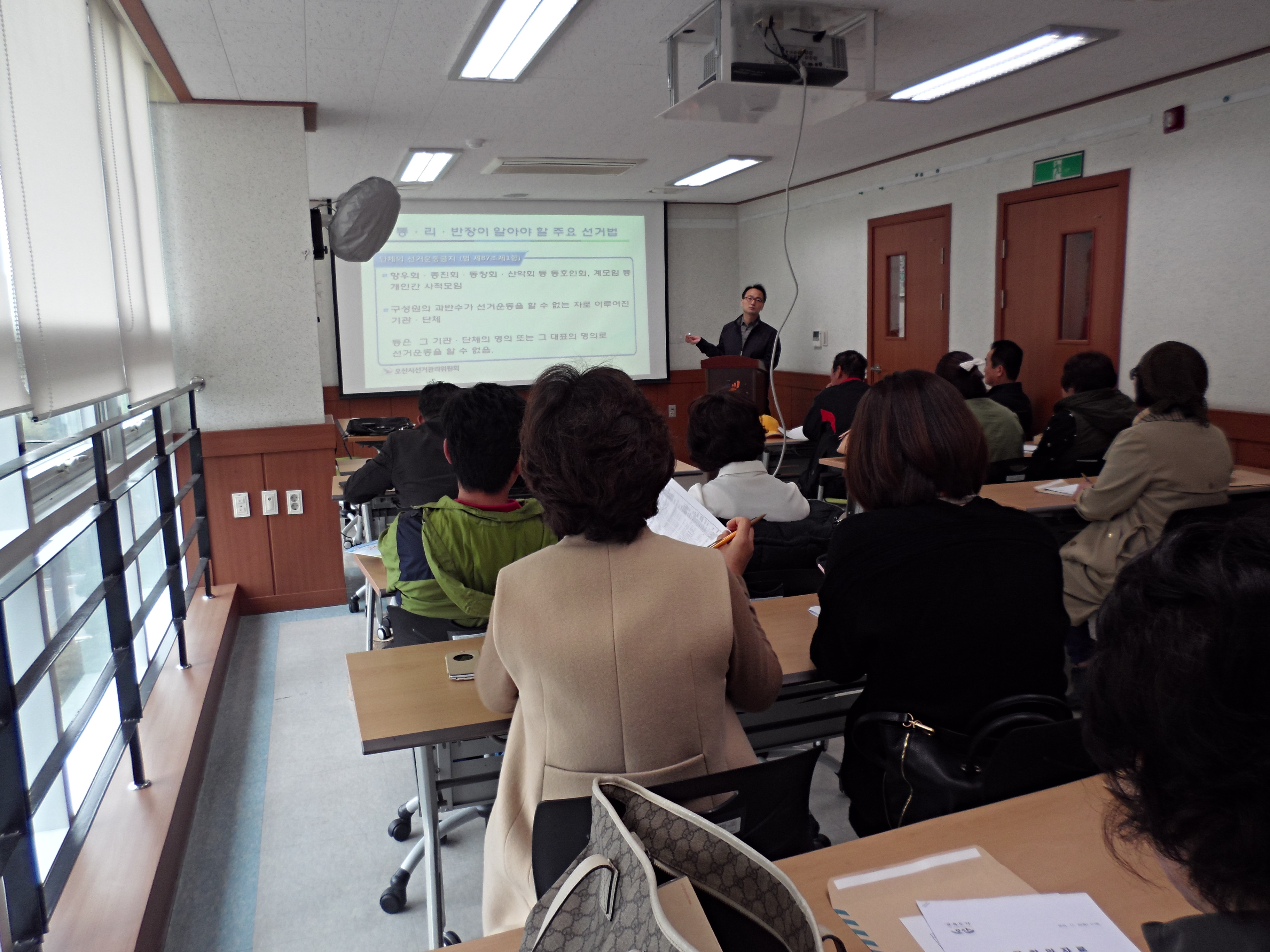 오산시선거관리위원회 관리계장이 세마동 통장단 회의를 이용하여 통장들이 알아야 할 주요 선거법에 대해 강의하고 있는 모습의 사진입니다