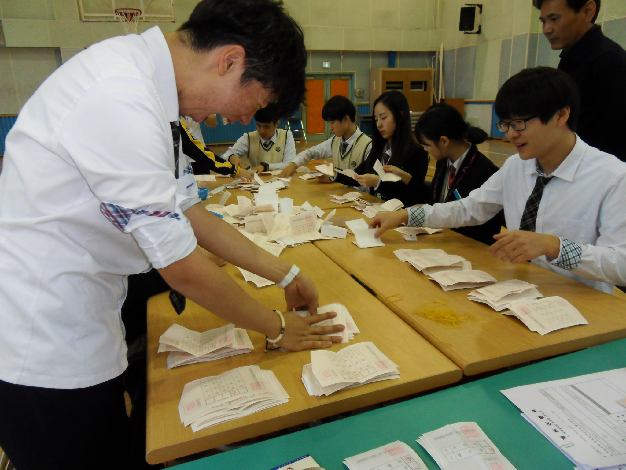 학생회 임원들이 투표지를 후보자별로 분류하고 있는 모습