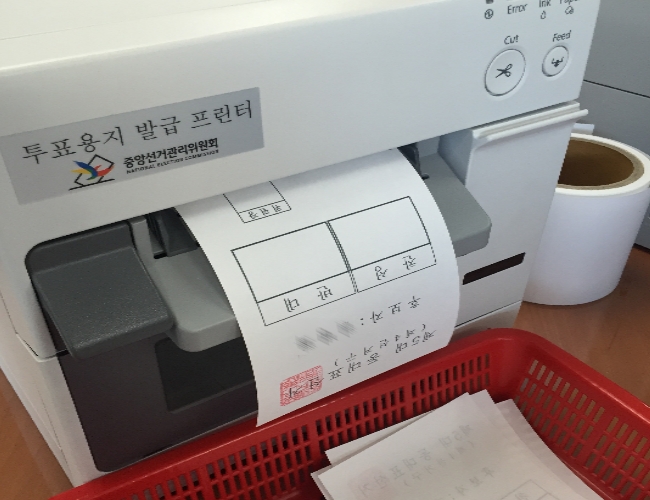 투표용지발급기를 활용하여 투표용지를 인쇄하고 있는 장면