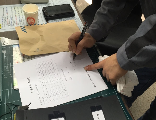 새터마을모아미래도 아파트 관리사무소에 투표용지를 전달하고 수령증을 받는 장면