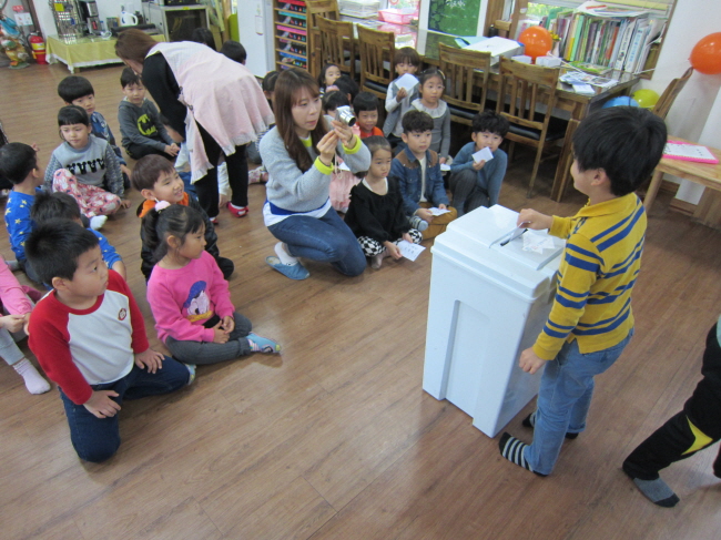 아이들이 투표함에 투표지를 넣는 모습