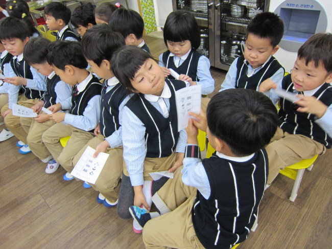 나눠준 투표용지를 신기하게 쳐다보는 아이들의 모습