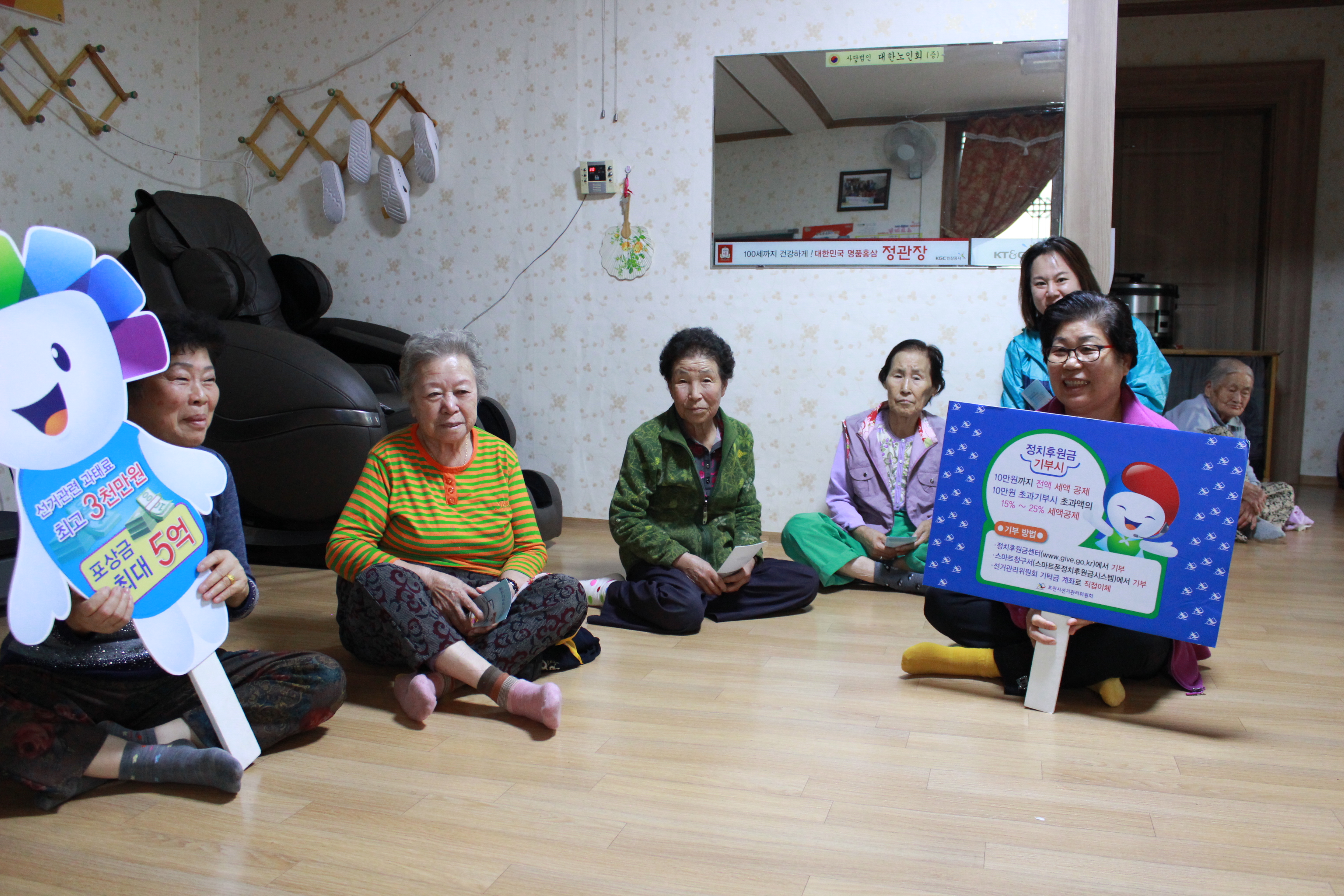  마을회관에 계시는 어르신들과 홍보용 피켓(과태료 및 포상금 제도 관련, 정치후원금 홍보)을 이용하여 기념사진 촬영
