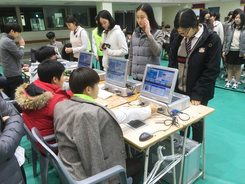 학생들이 회장단선거에서 본인확인기를 이용하여 투표권을 발급하는 모습