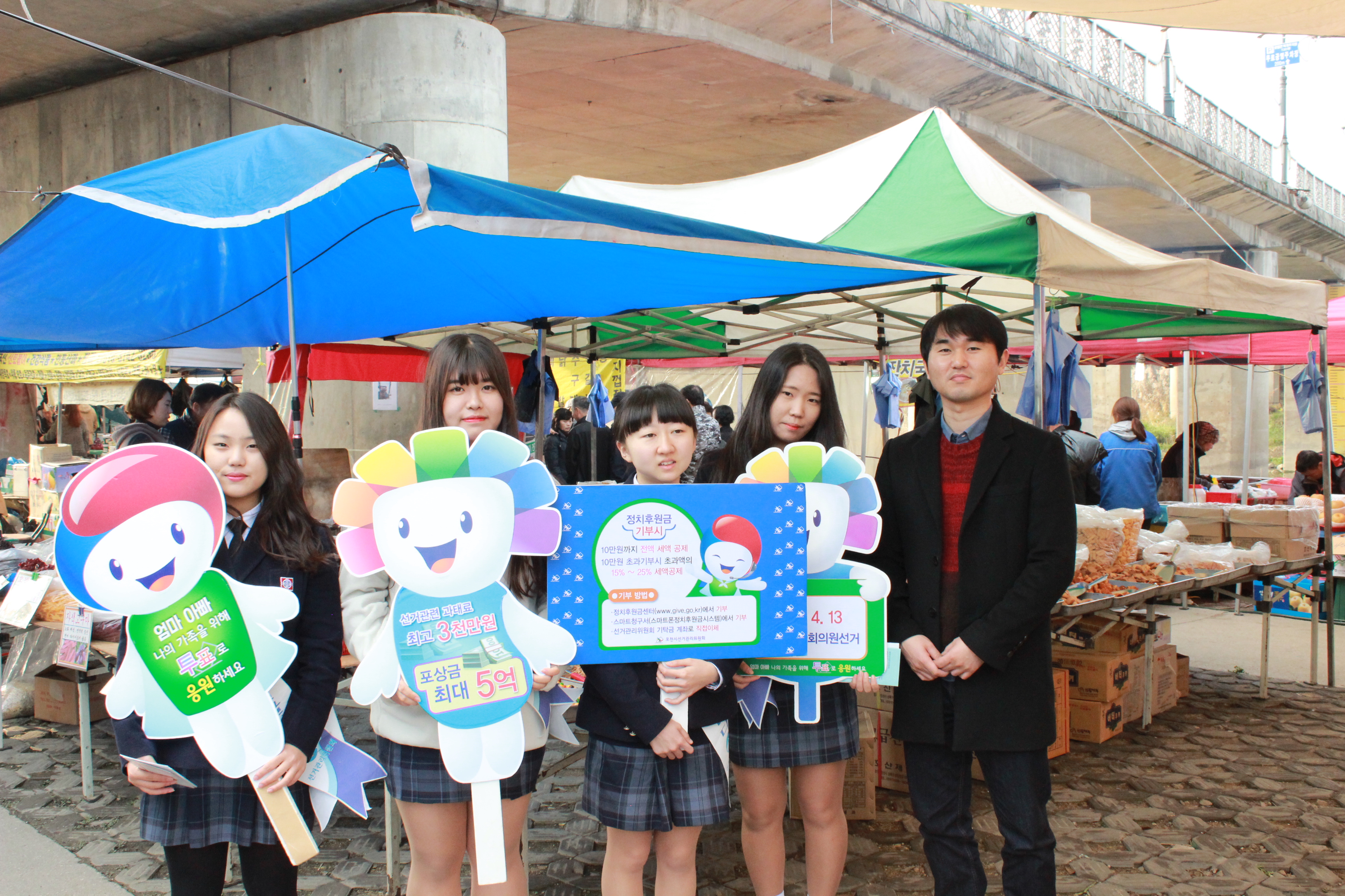 일동고 시사탐구반 학생 및 담임 교사와 함께 전통시장 장터에서 기념사진을 촬영하는 모습