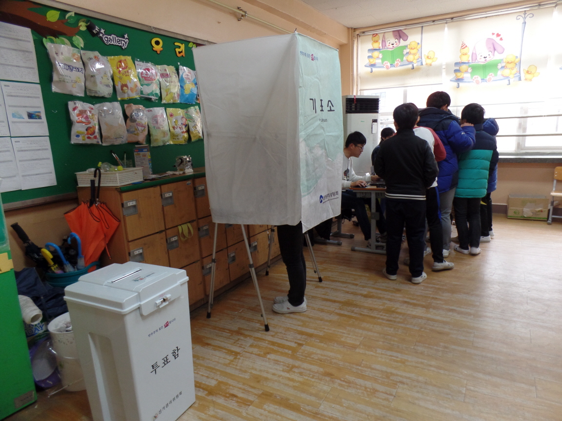 학생들이 투표용지발급기 등을 이용하여 선거체험을 하고 있는 모습