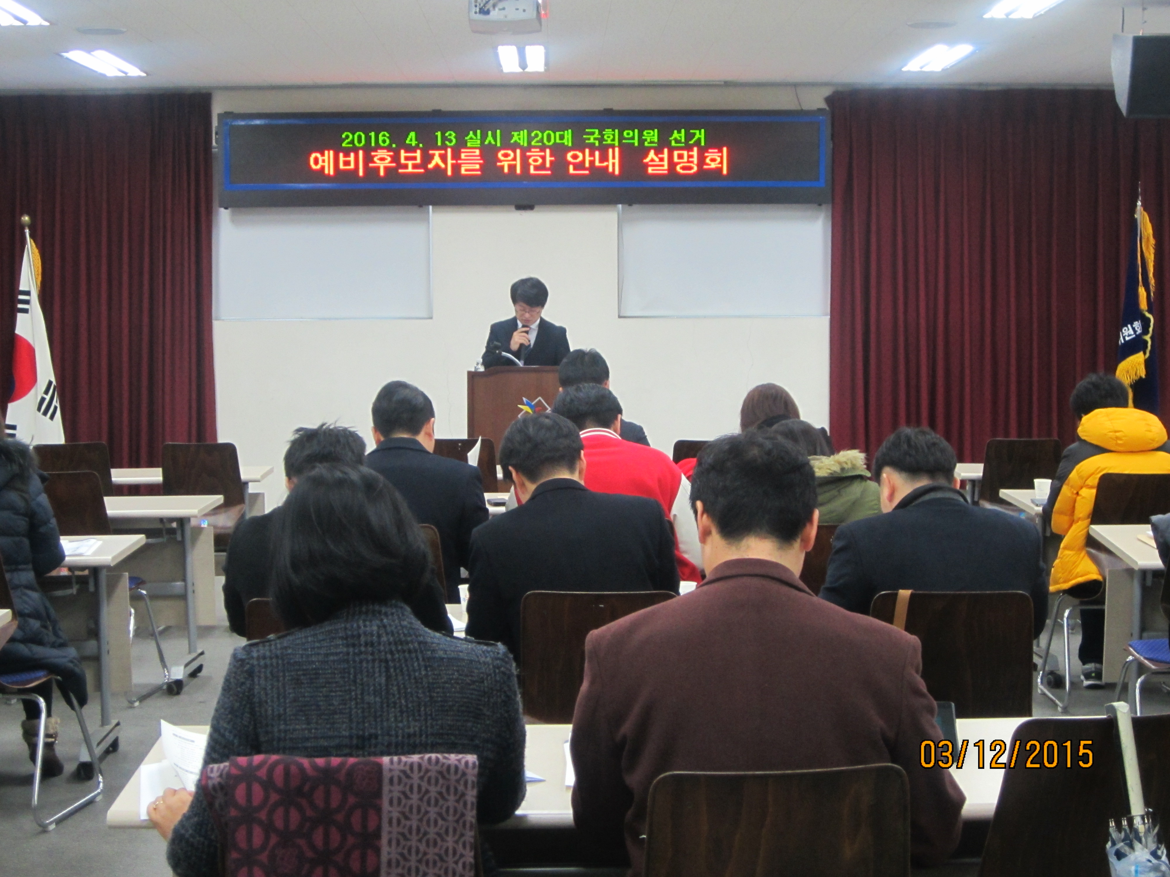 관리계장이 예비후보자 등록 신청 서류 작성방법 등을 설명하고 있는 모습