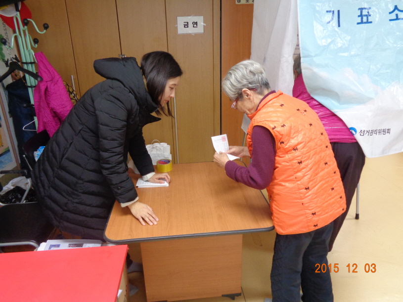 경로당 어르신들이 모의투표용지를 이용하여 선거체험을 하고 있는 모습