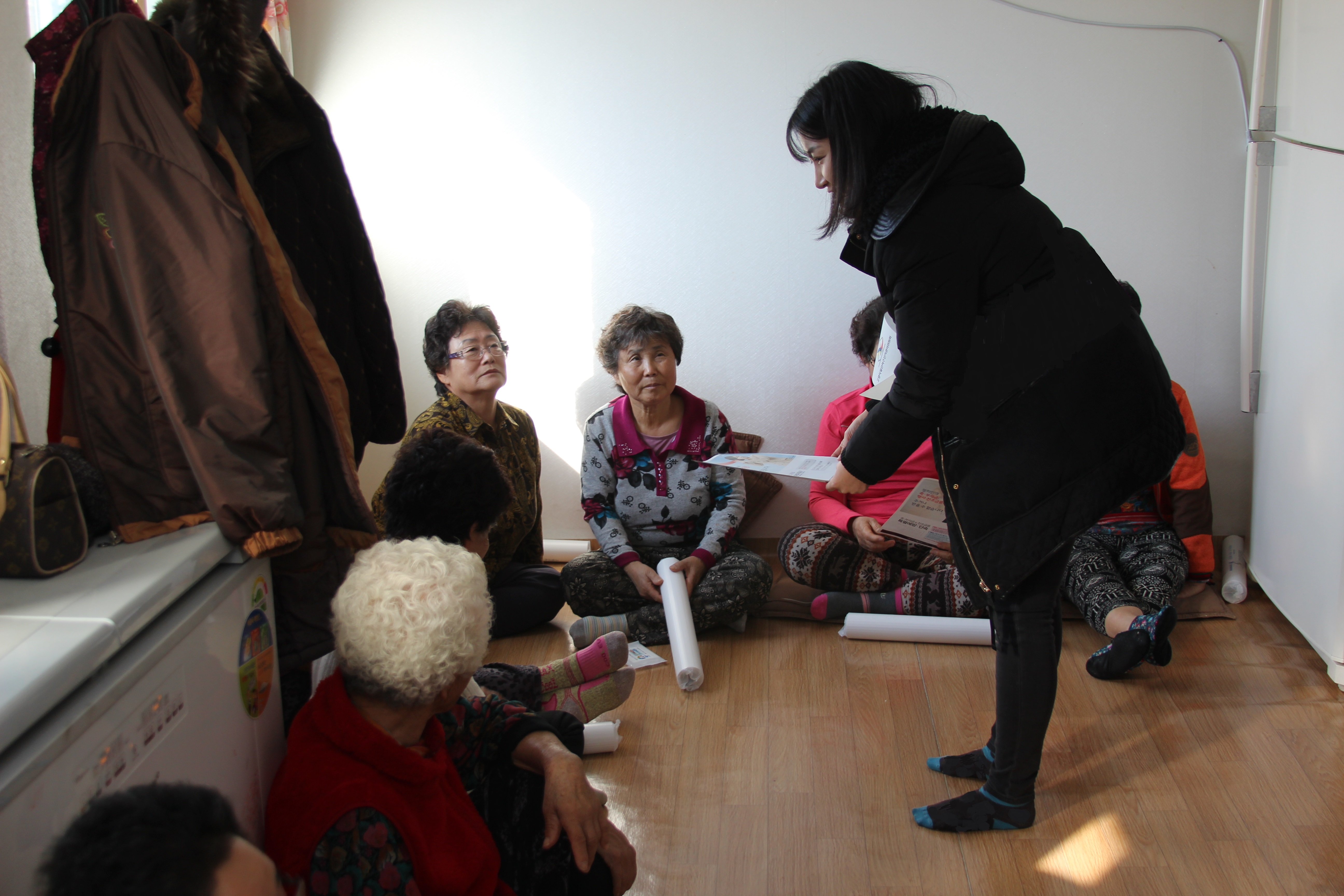 위원회 조미선 홍보주임이 경로당을 방문하여 과태료 · 포상금에 대하여 안내하는 모습