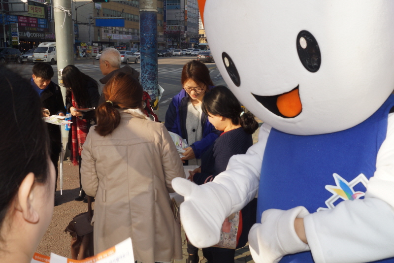 위원회 직원 등이 시민들에게 기부행위관련 제도 안내 및 홍보용품과 홍보전단을 배부하는 모습의 사진입니다.