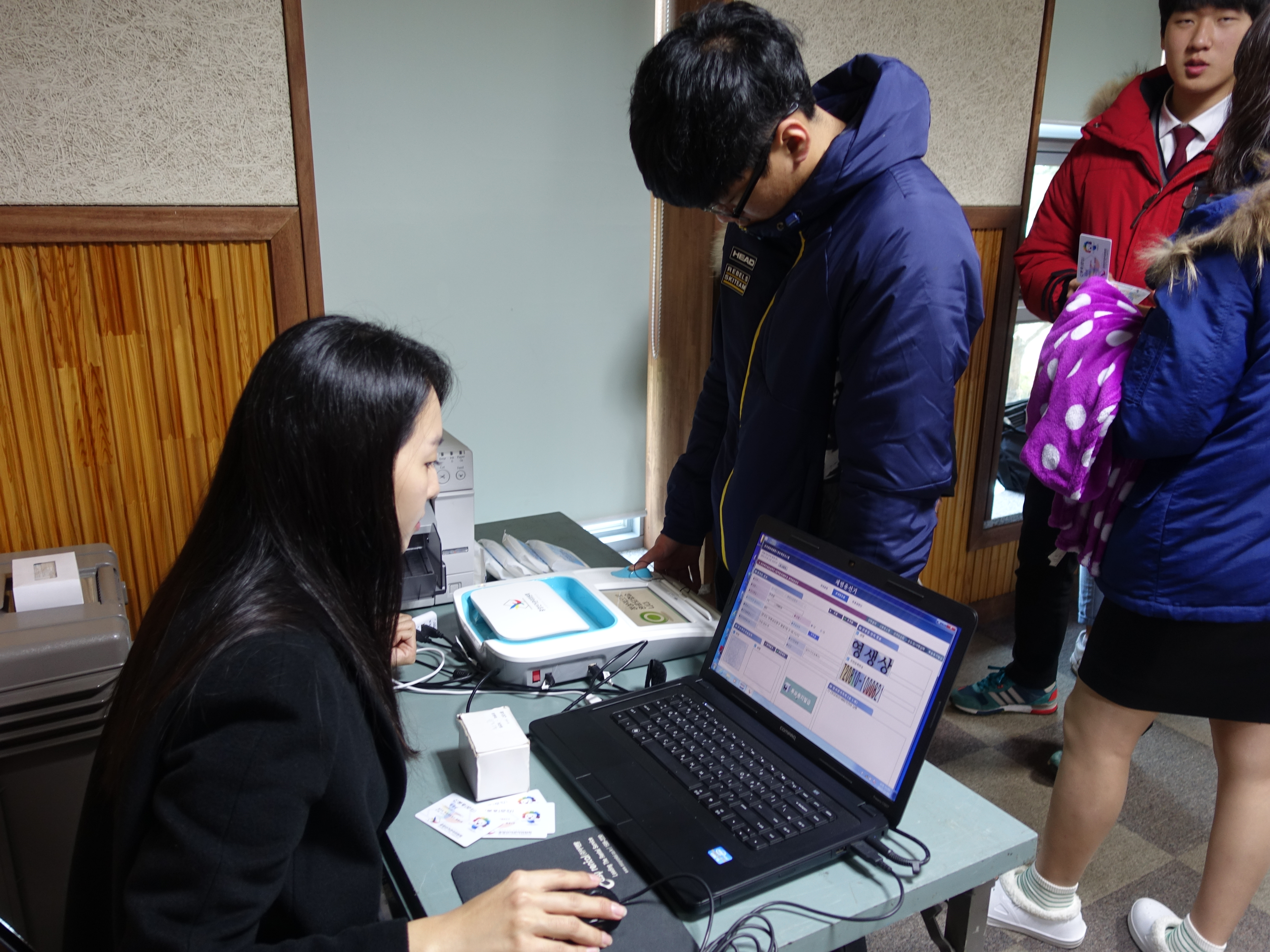 학생이 사전투표운용장비를 이용한 투표용지발급을 직접 체험해보고 있는 모습