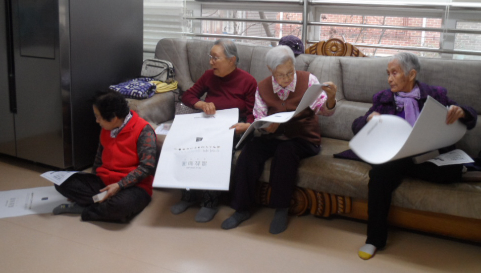 할머니들이 공명선거 홍보달력을 보시는 모습