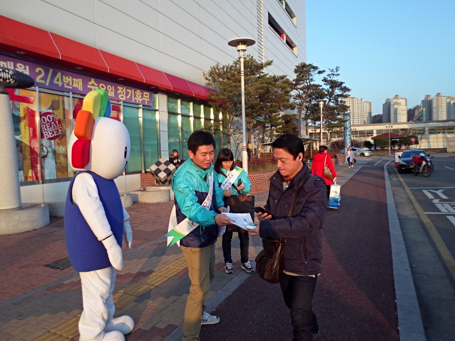 오산시선관위 직원들이 홈플러스를 이용하는 시민들에게 홍보용품을 나누어 주며 선거법 위반행위에 대한 신고 및 제보를 당부하고 있는 모습의 사진입니다